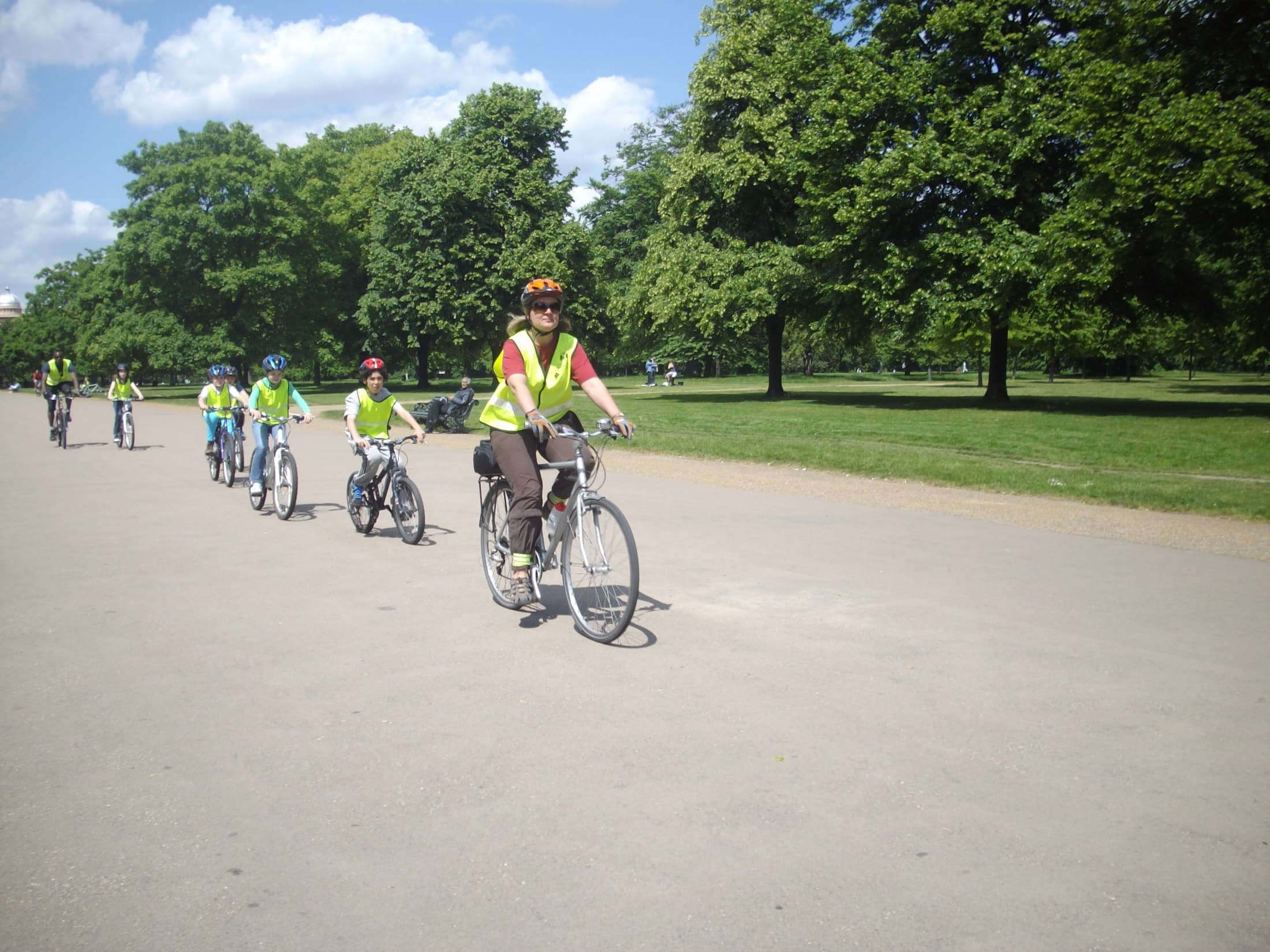 Children cycling with a coach in a public park